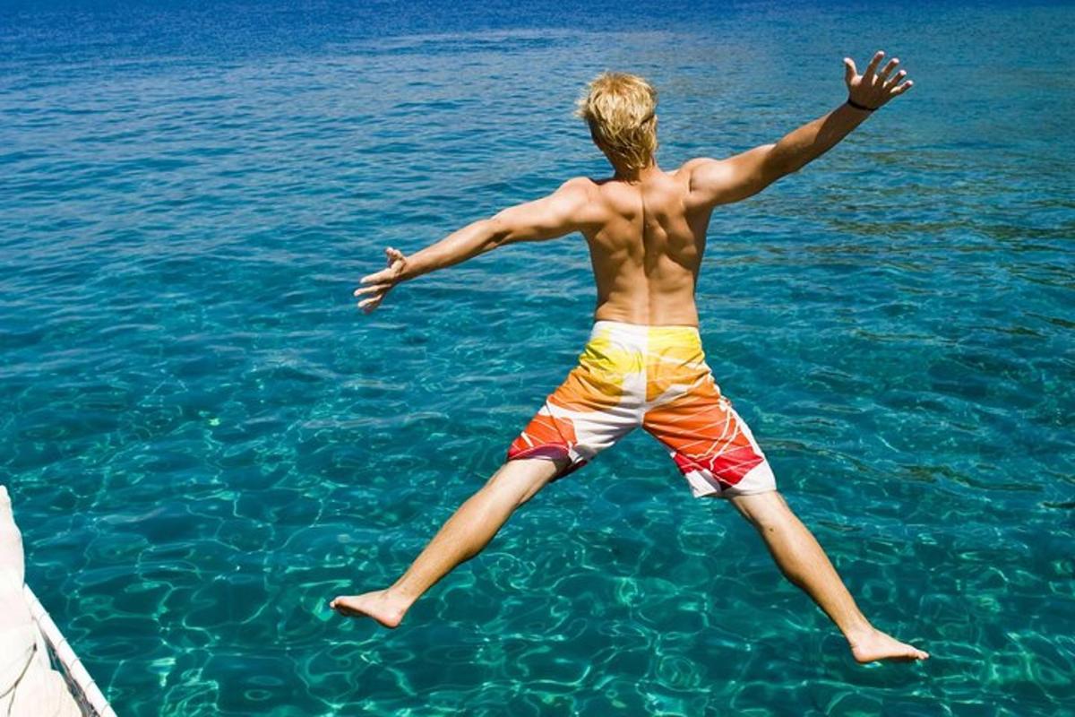 a young man jumping into the water in the water