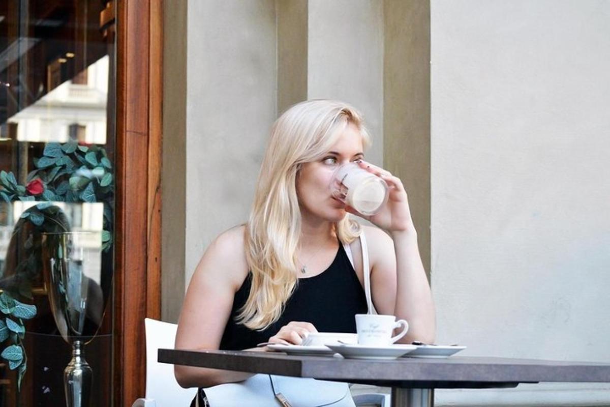 una donna seduta a un tavolo che beve una tazza di caffè