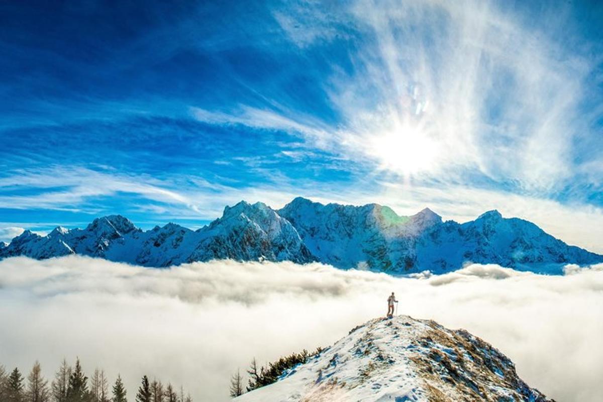 a person standing on top of a mountain above the clouds