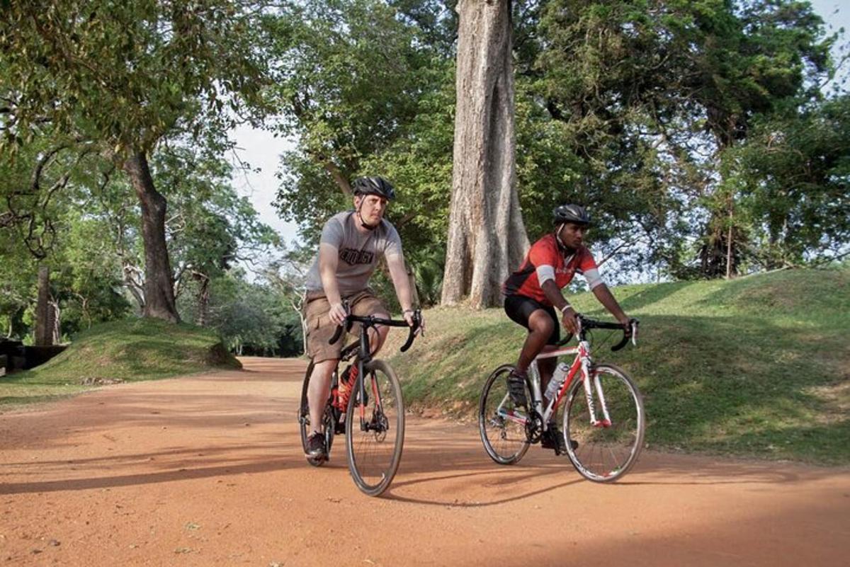 due persone in bicicletta lungo una strada sterrata