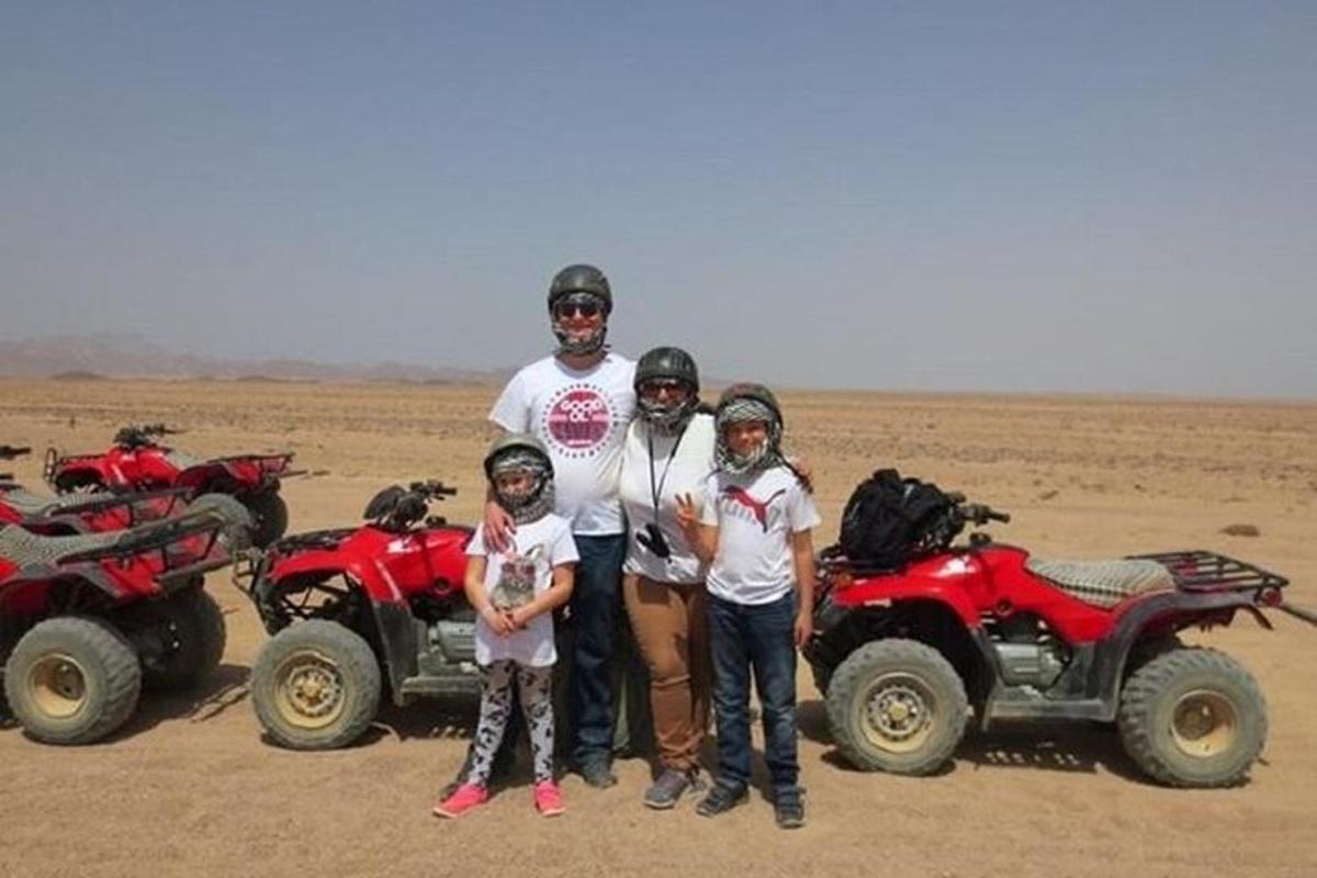 a group of people standing in front of atvs in the desert