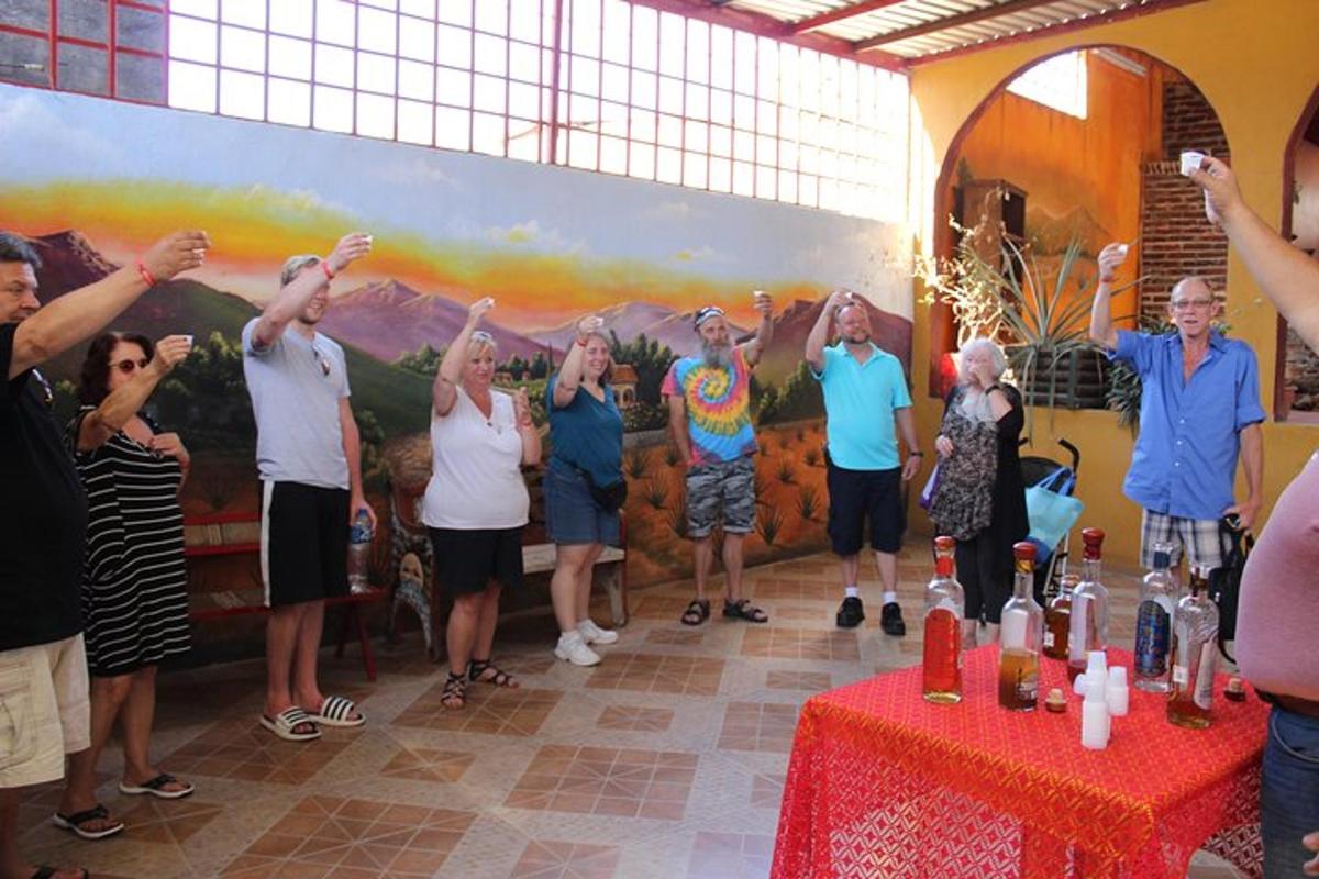 grupė žmonių, stovinčių kambaryje pakėlę rankas į viršų