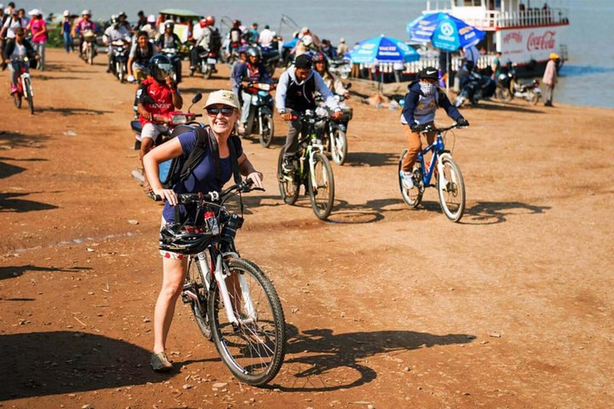 a group of people riding bikes on the beach