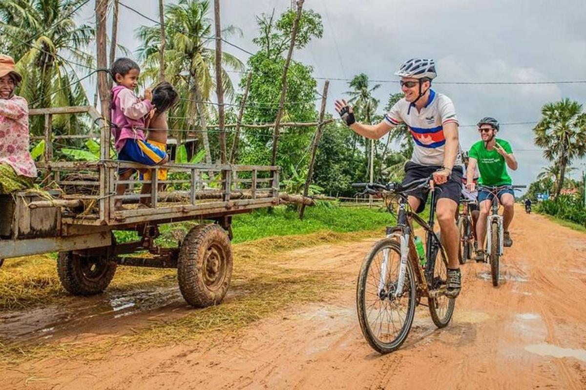 a group of people riding bikes down a dirt road with a truck
