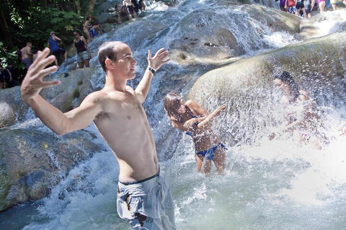 sekelompok orang di dalam air di air terjun