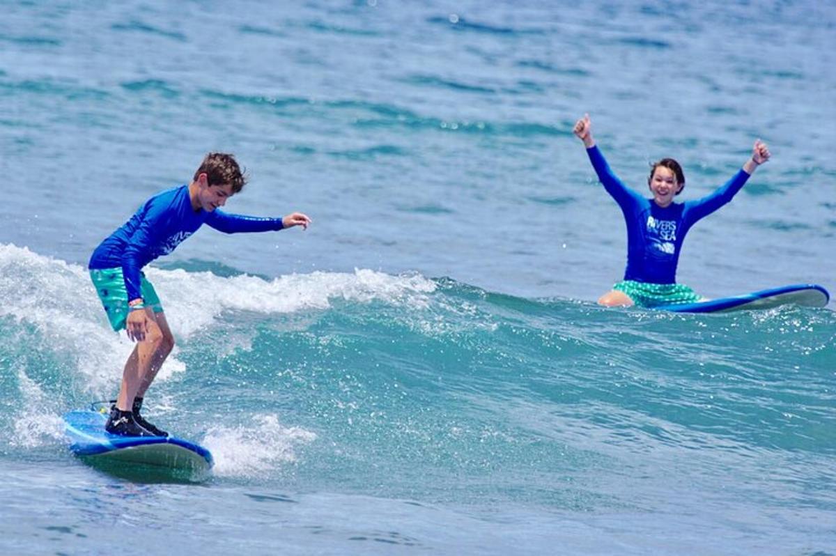 dva lidé jedoucí na vlně na surfových prknech v oceánu