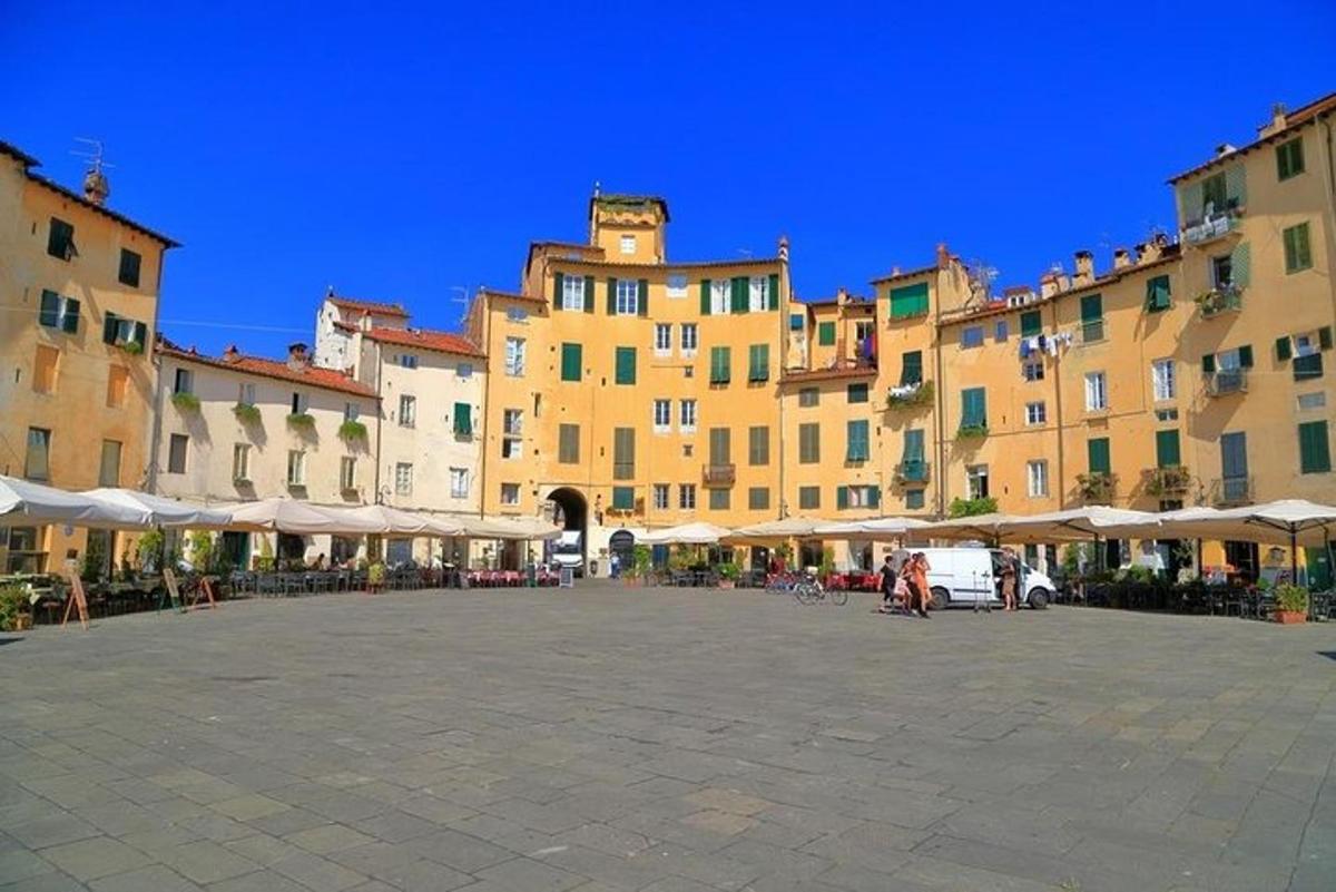un gruppo di edifici con tavoli e ombrelloni in un cortile