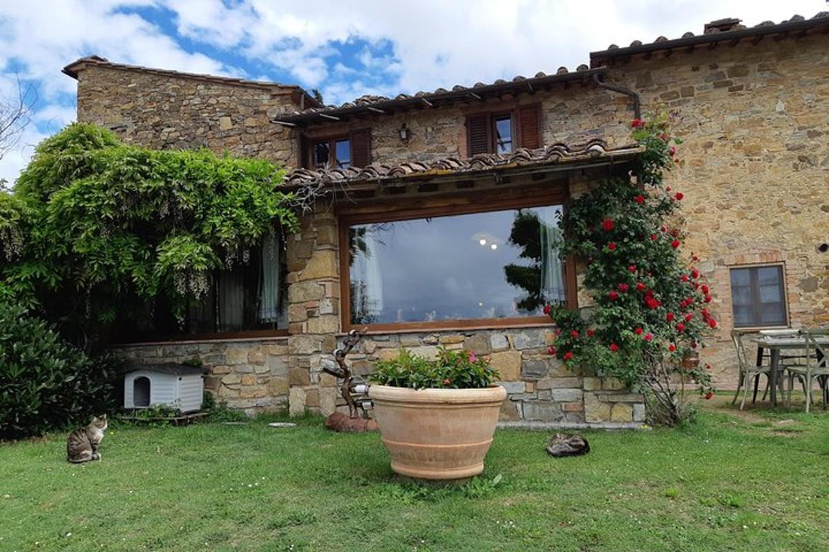 una casa in pietra con un grande vaso di fiori nel cortile