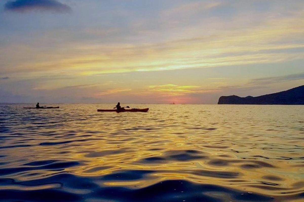 dua orang dalam bot di atas air pada waktu matahari terbenam
