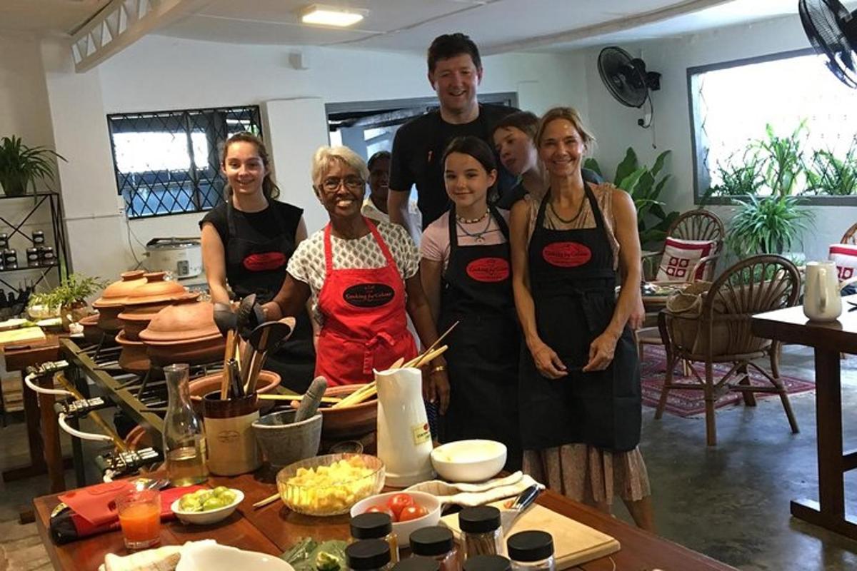 a group of people wearing aprons standing in a kitchen