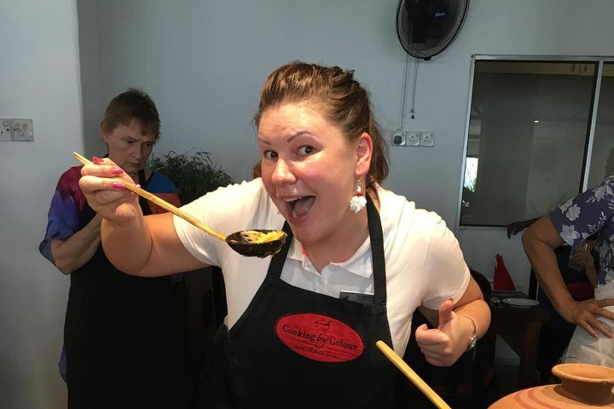 a woman holding chopsticks with food in her mouth