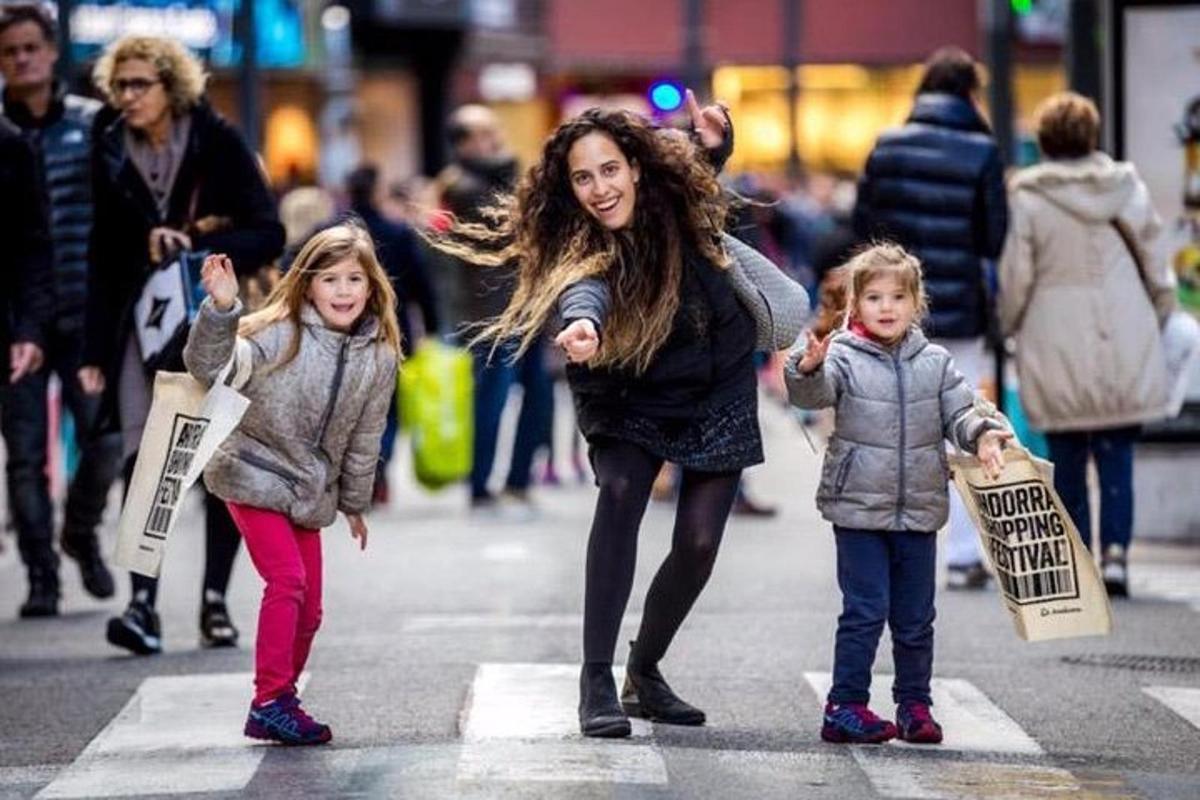 uma mulher e duas crianças atravessando uma rua