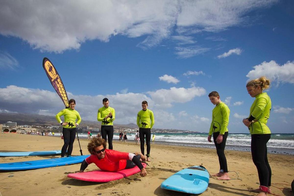 un gruppo di persone in piedi su una spiaggia con tavole da surf