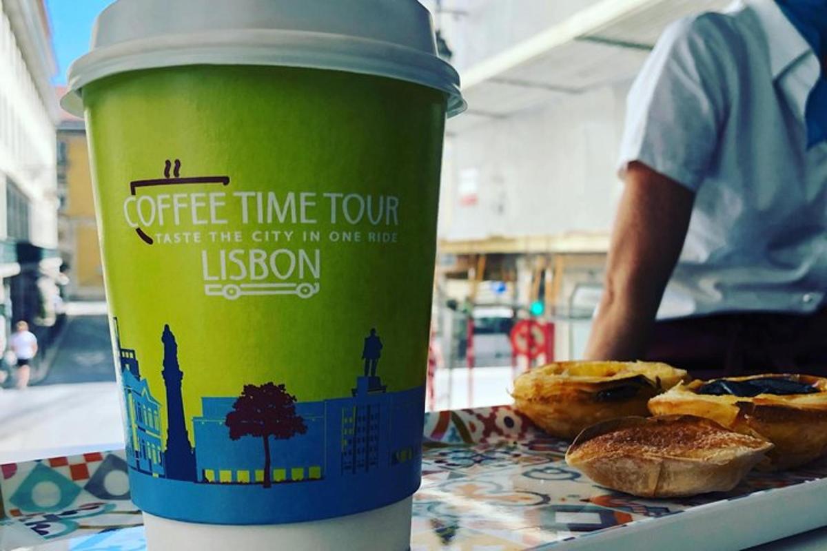 una tazza di caffè verde appoggiata su un tavolo con dei pasticcini