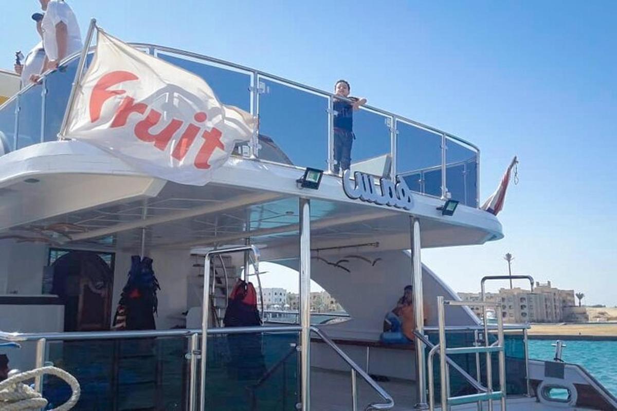 un gruppo di persone in piedi sul ponte superiore di una barca
