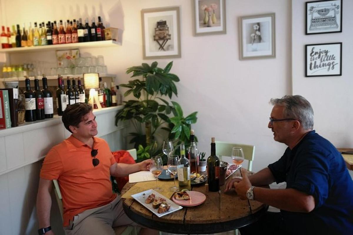 two people sitting at a table with wine glasses