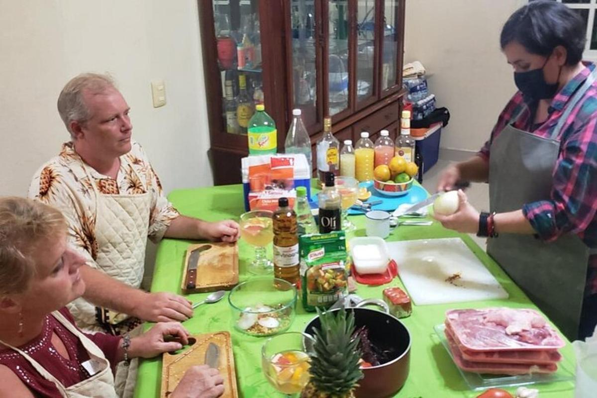 un gruppo di persone in piedi attorno a un tavolo con del cibo