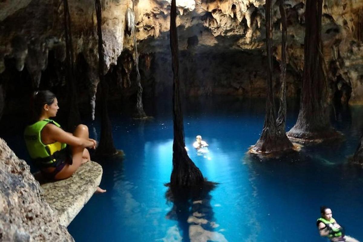 Un grupo de personas sentadas en un estanque de agua en una cueva.