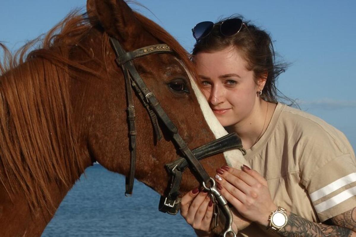 a woman standing next to a brown horse