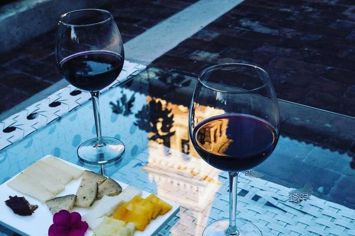 dos copas de vino tinto y un plato de comida
