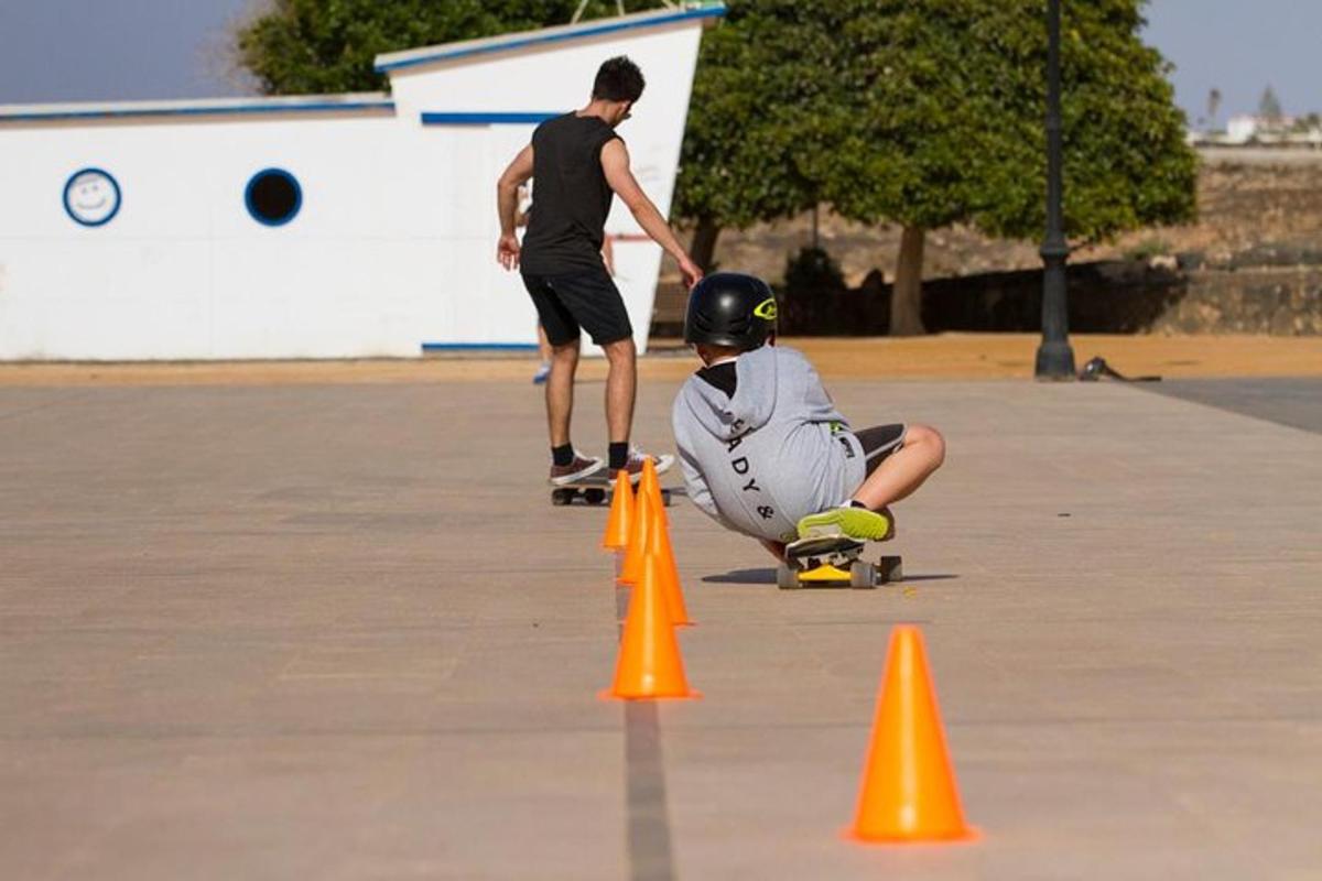 due uomini stanno andando sullo skateboard intorno ai coni arancioni