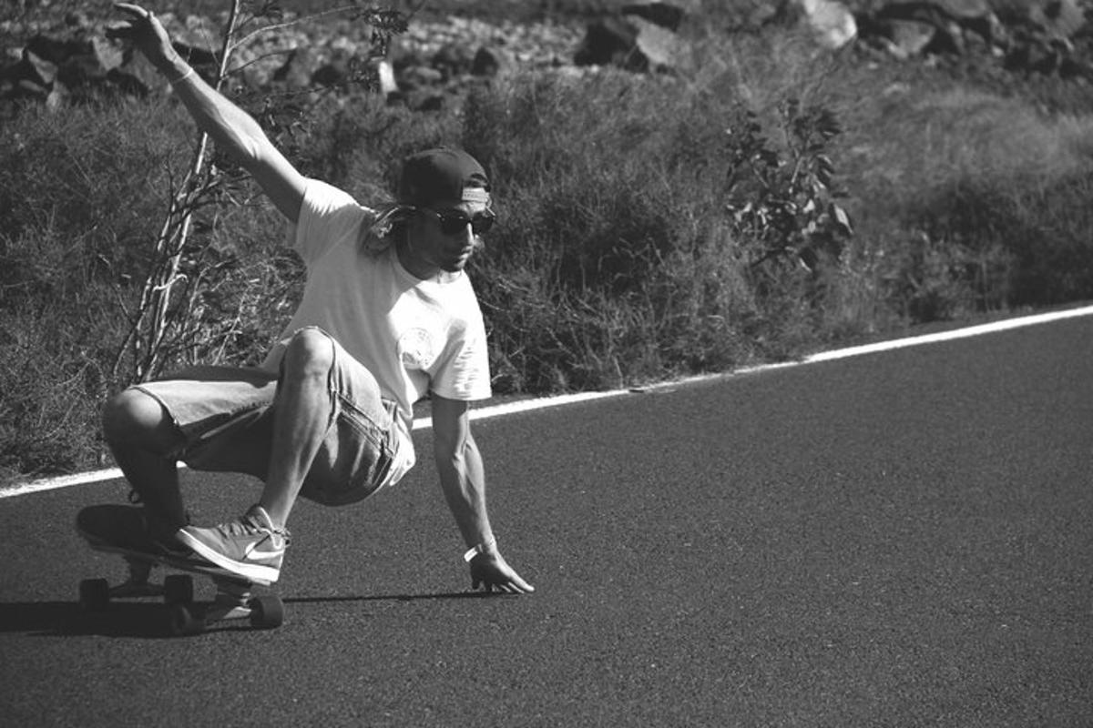 un uomo che va sullo skateboard lungo una strada