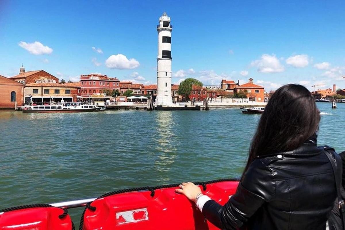 una donna su una barca sull'acqua con un faro