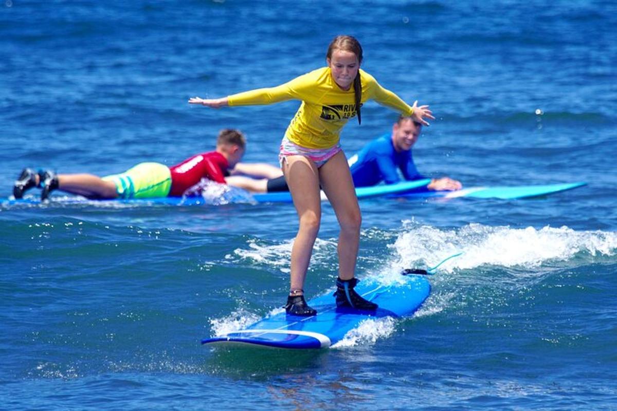 uma jovem em pé em uma prancha de surfe na água