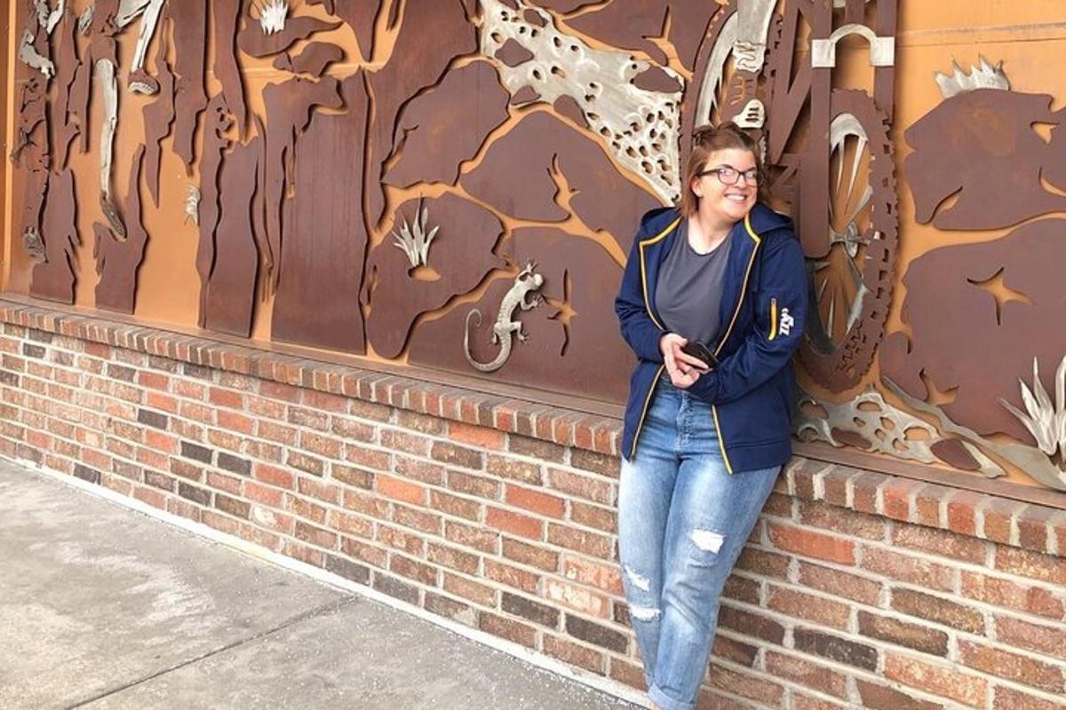 a woman standing next to a brick wall