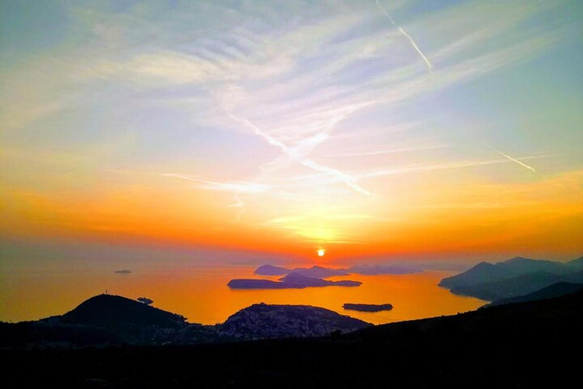 en solnedgang over en vannmasse med fjell