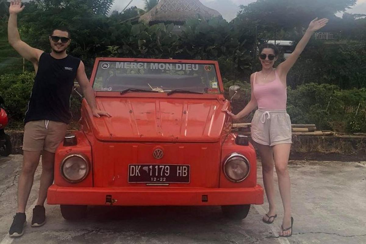 muž a žena stojící vedle červeného auta