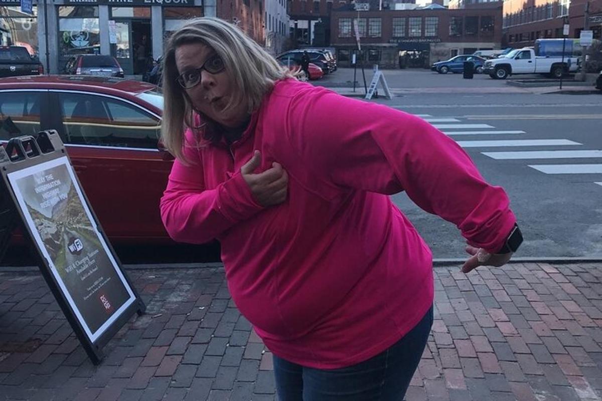 una donna con una maglietta rosa che cammina per strada