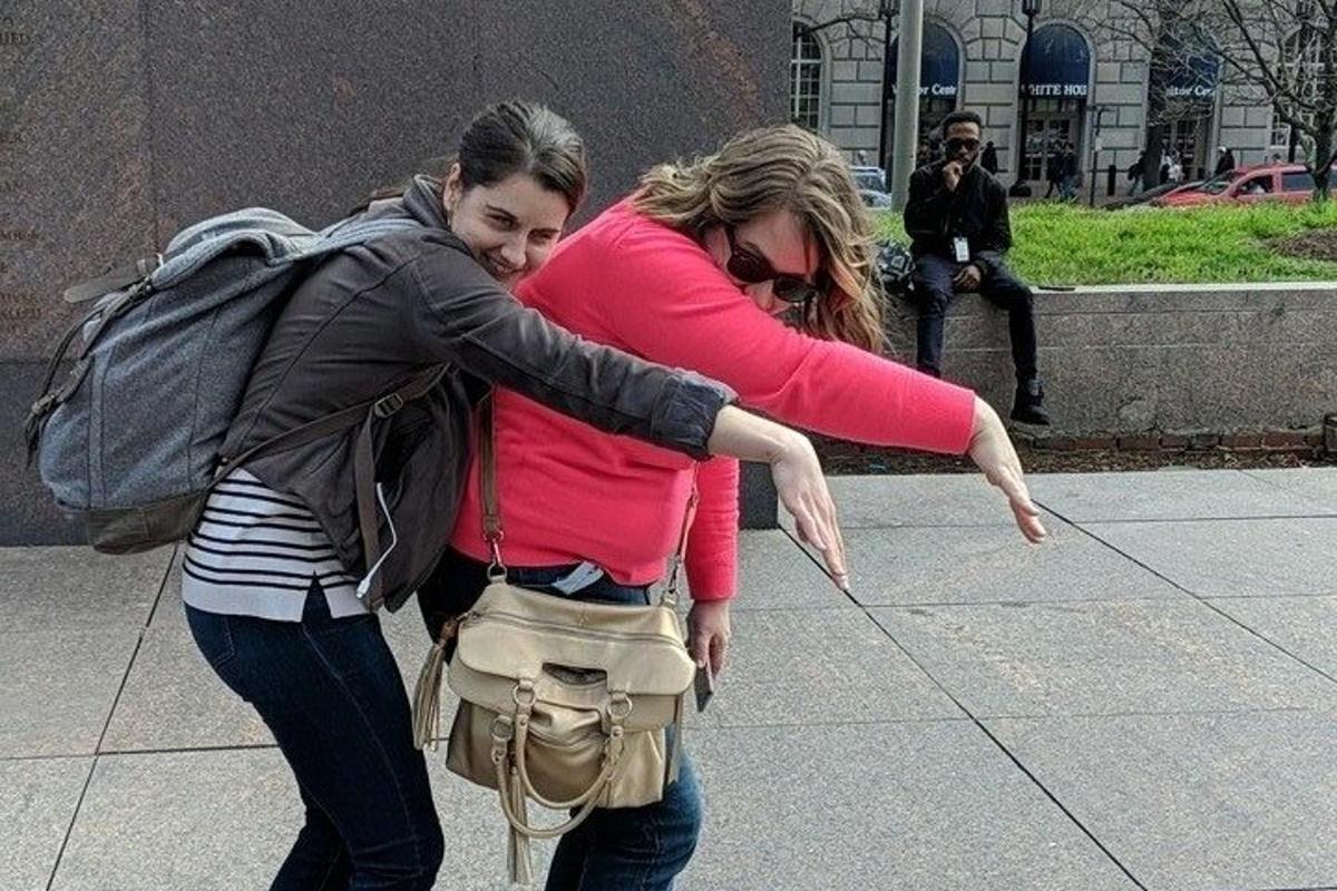 two women walking down a sidewalk with a man