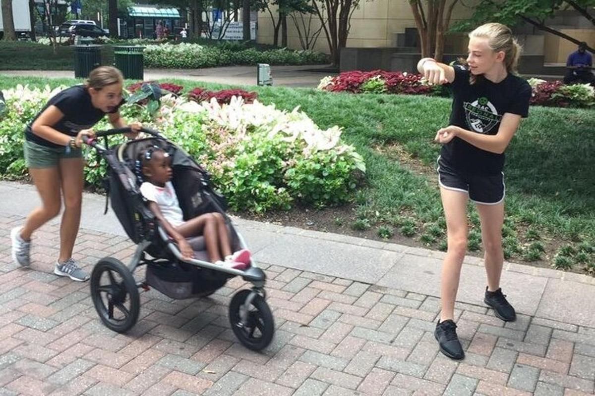 Dos niñas jugando con un niño en un cochecito