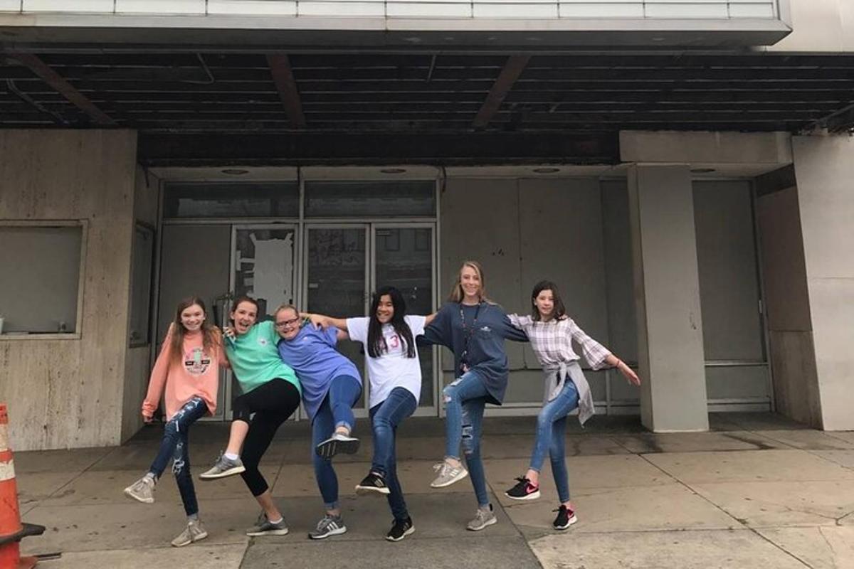 a group of people are posing in front of a building