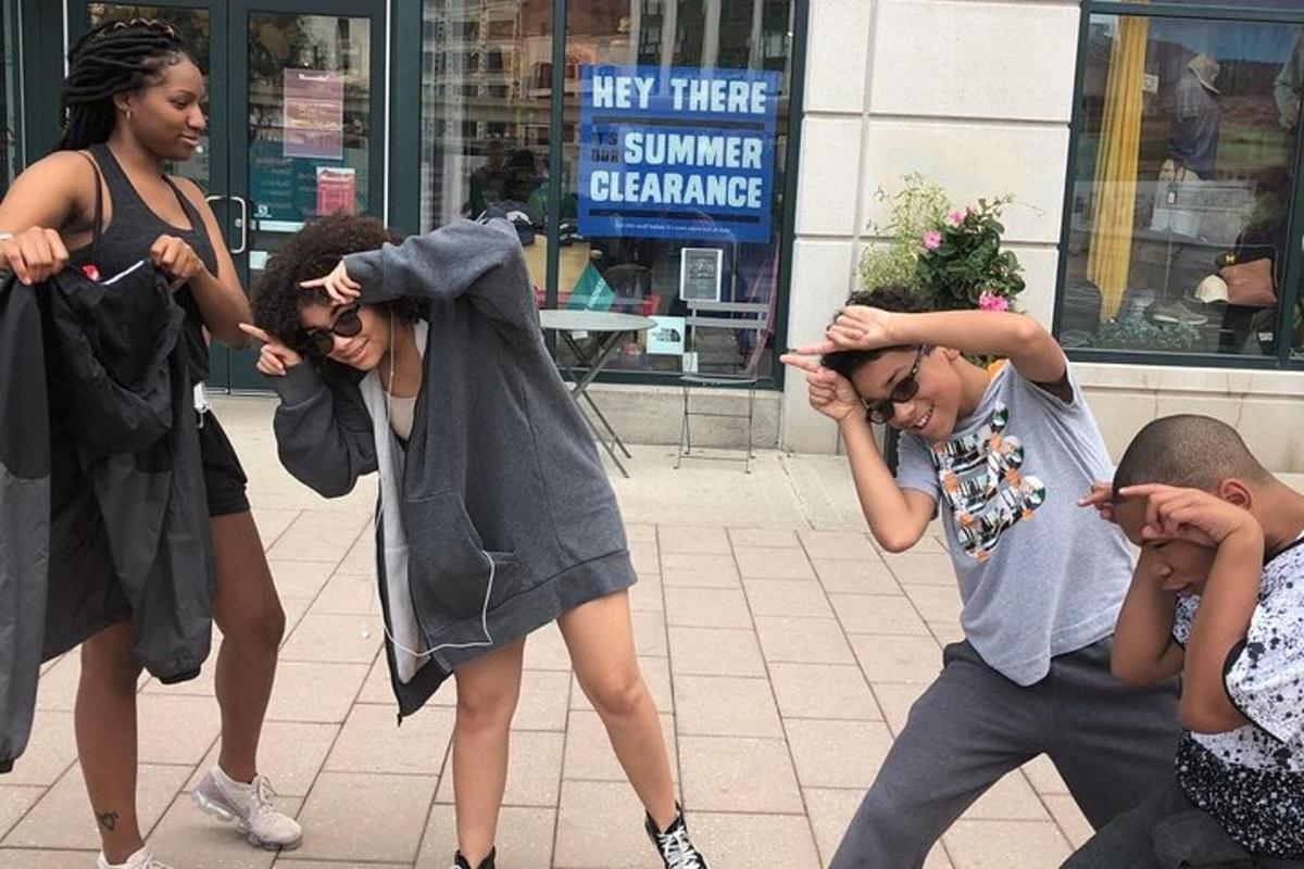 un gruppo di persone che ballano su un marciapiede