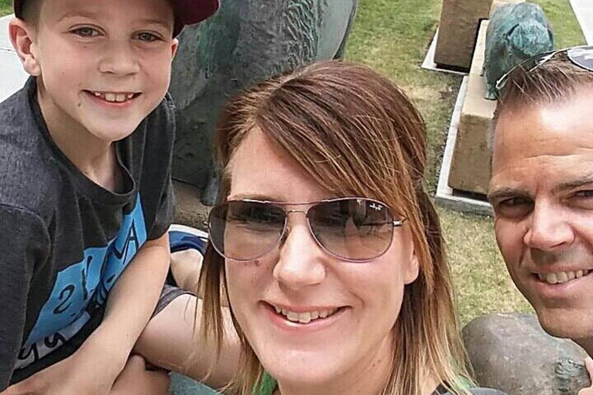 una donna, un uomo e un bambino posano per una foto