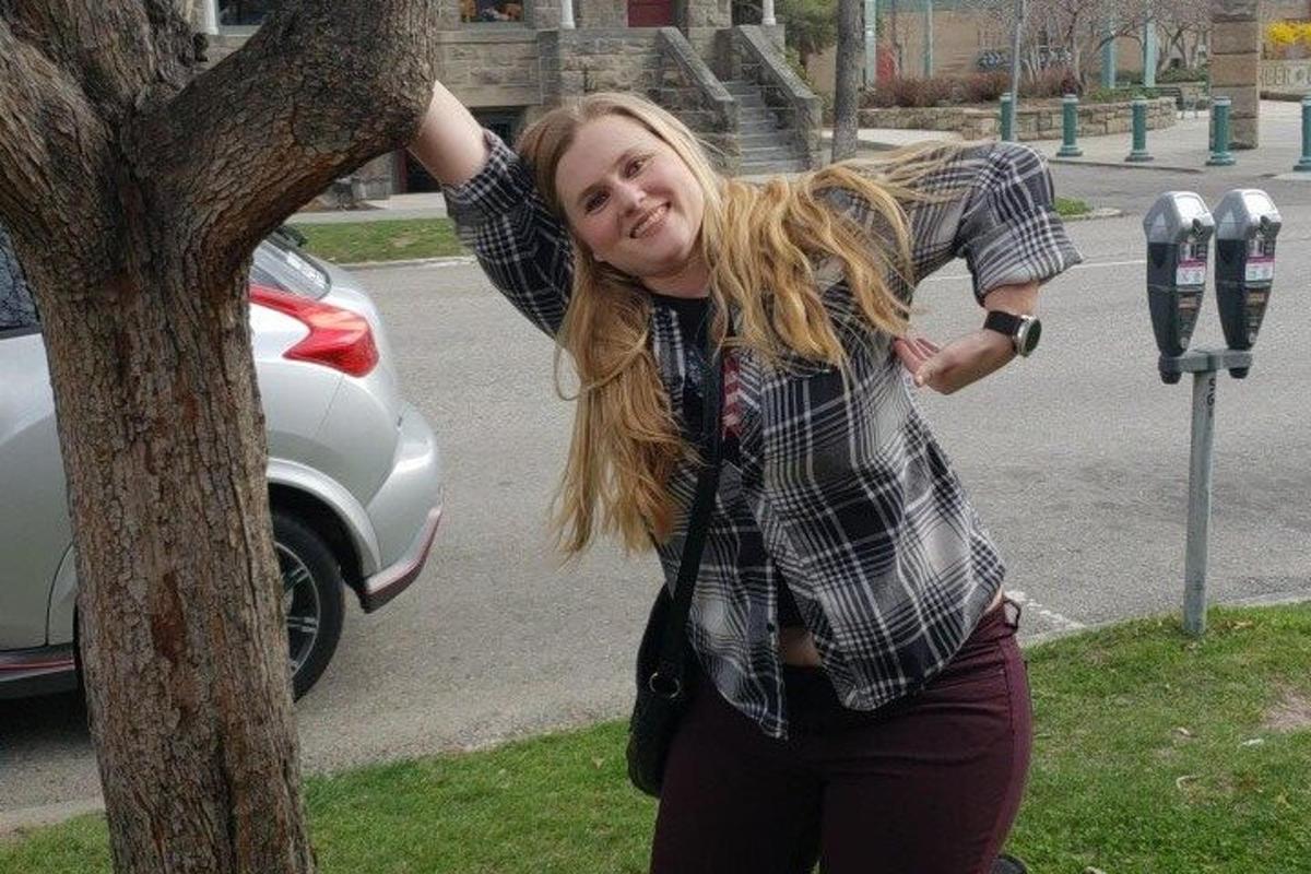 žena stojící vedle parkovacího automatu