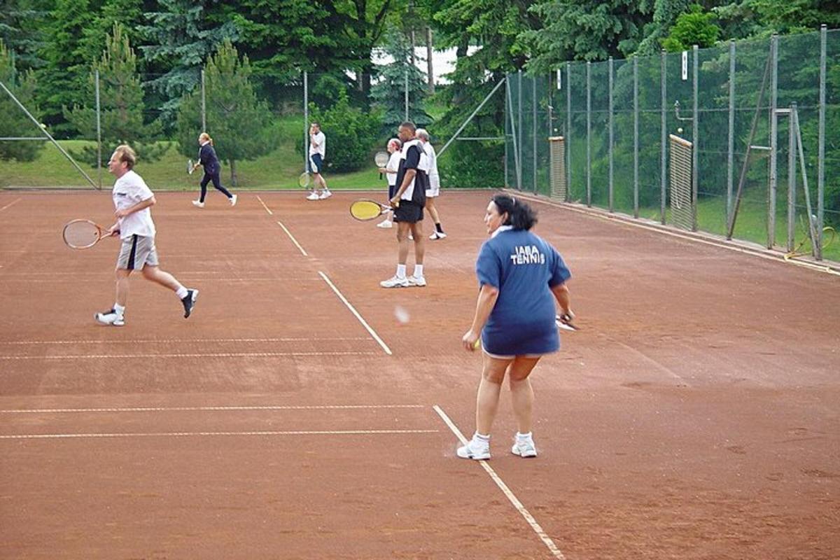 skupina ljudi, ki igrajo tenis na teniškem igrišču