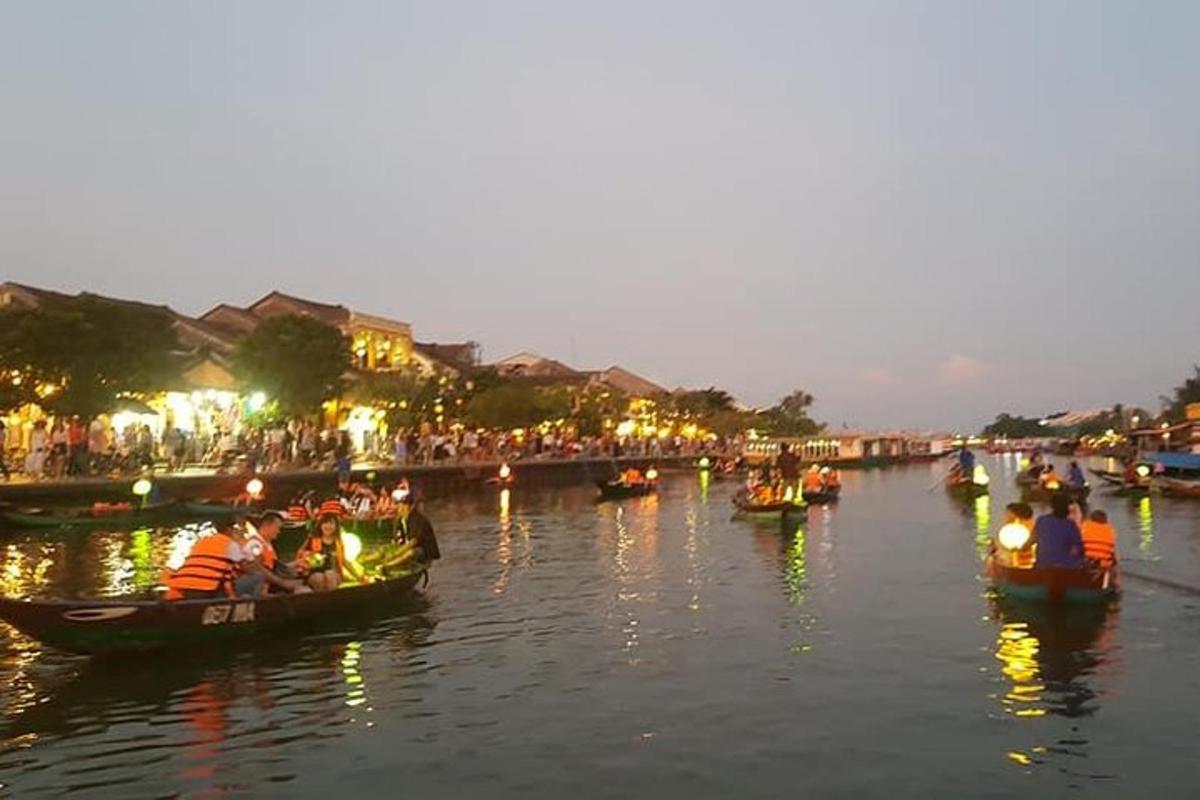 Un grupo de personas en botes en un río por la noche.