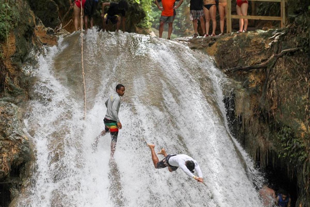 duas pessoas em pé no topo de uma cachoeira