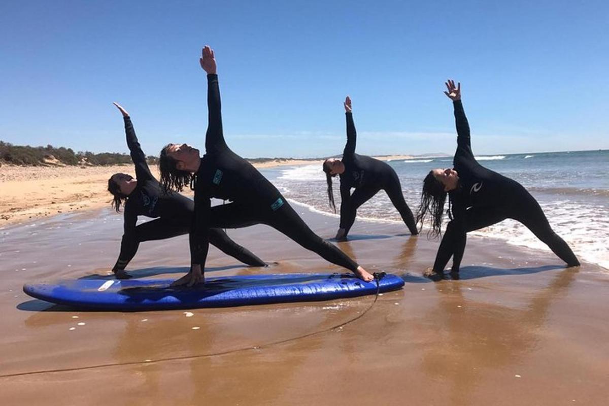 a group of people standing on a surfboard on the beach