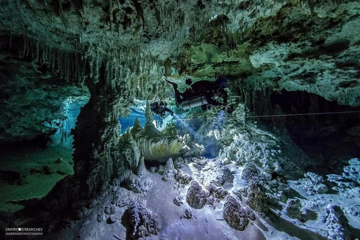 um homem está parado em uma caverna em um rio