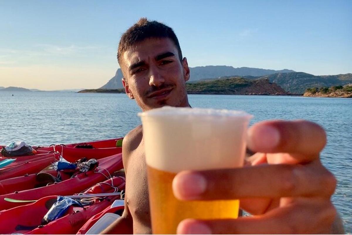 a man holding a glass of beer in his hand
