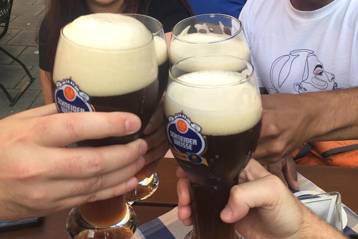 duas pessoas estão segurando copos de cerveja