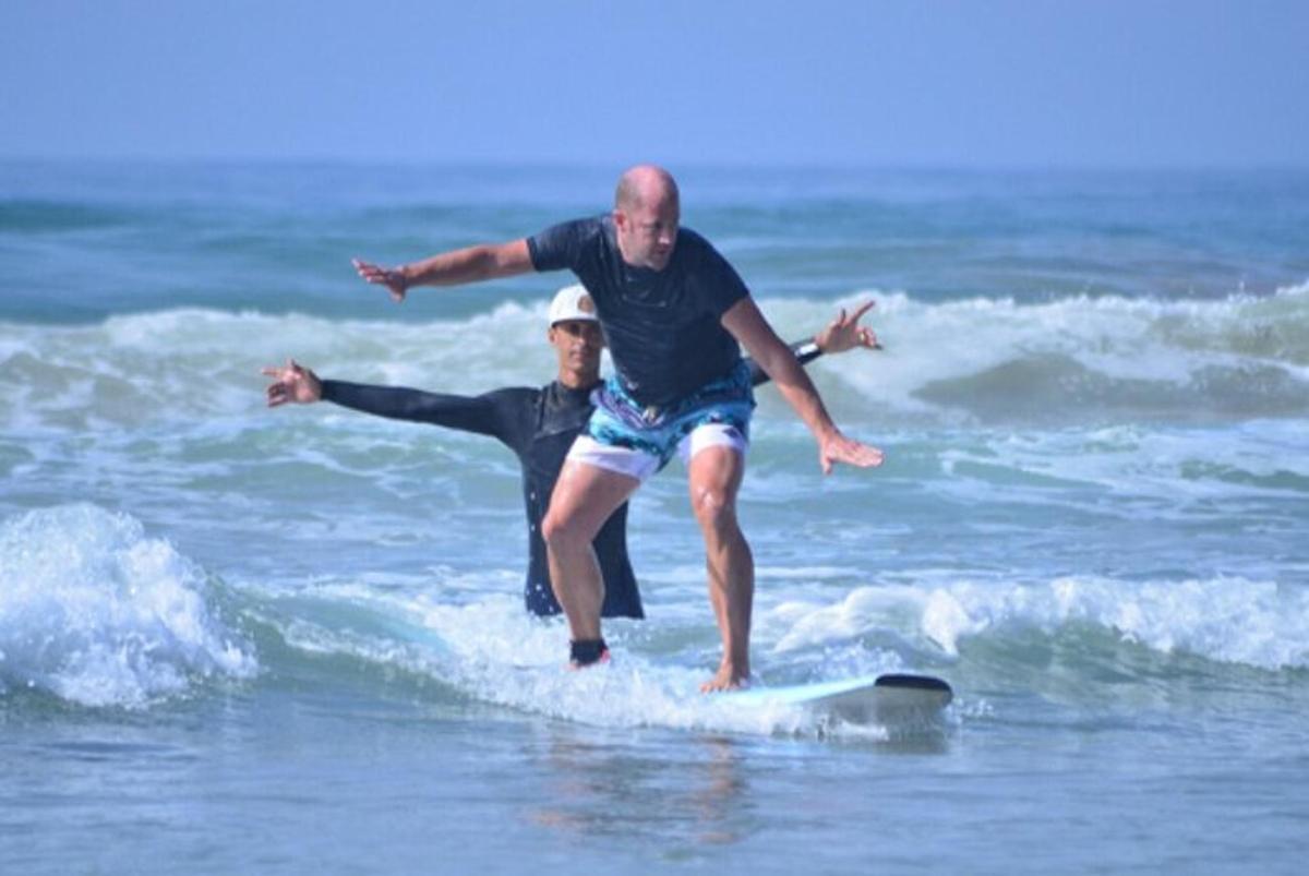 two people riding a wave on a surfboard in the ocean
