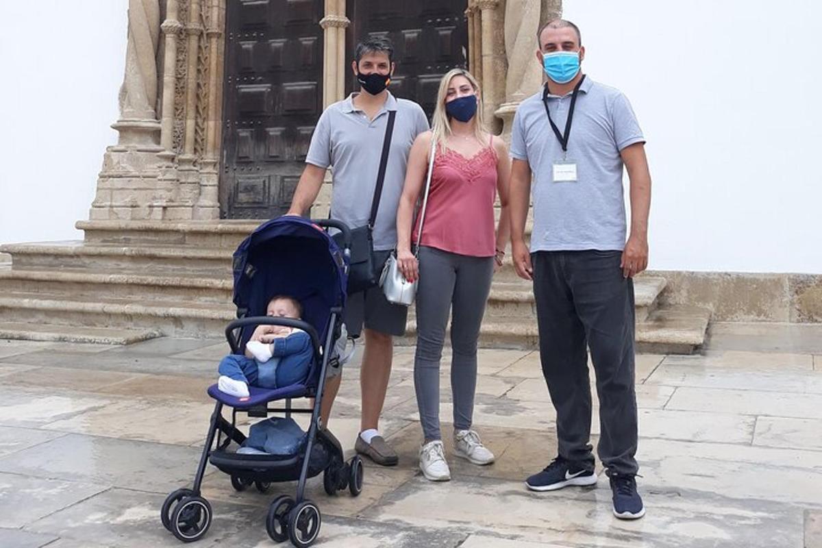 a group of three people wearing masks standing in front of a building