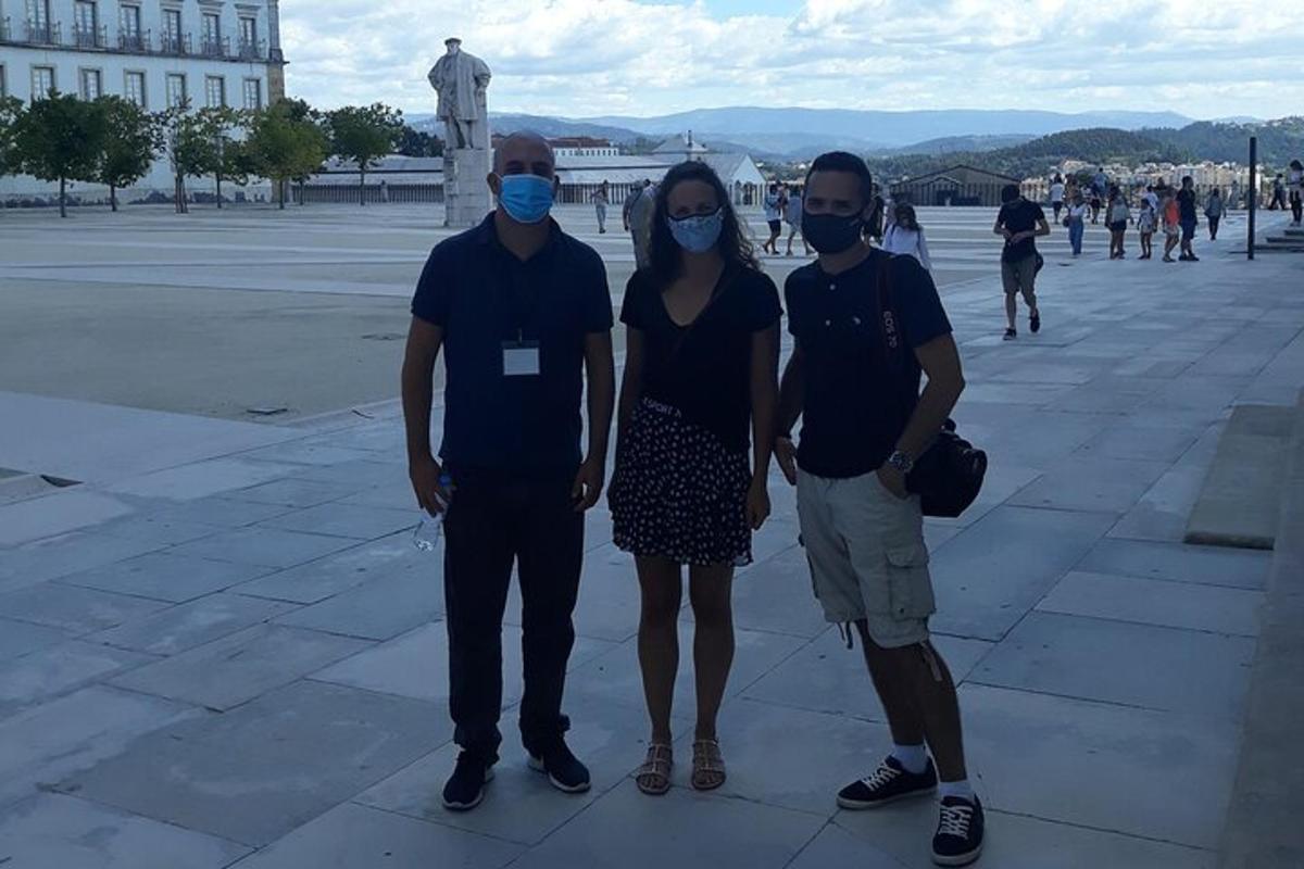 tres persones amb mascaretes dempeus en una plaça