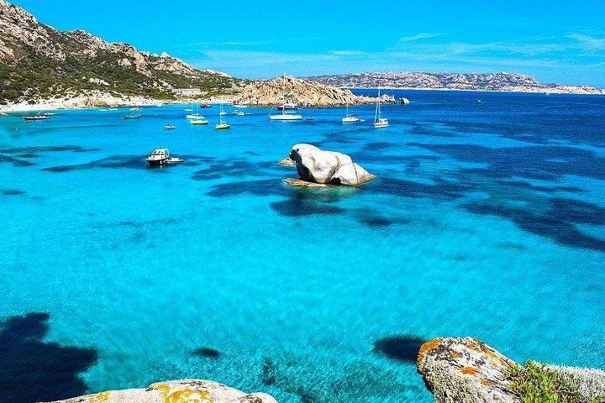 an elephant in the water with boats in the ocean