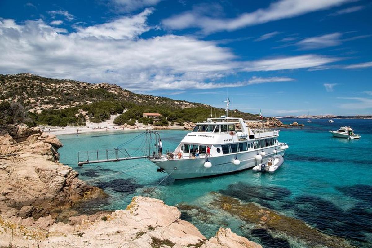 a boat docked in the water near a beach